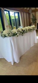 All white garland used as a garland for the Ceremony and then moved to the top table 
