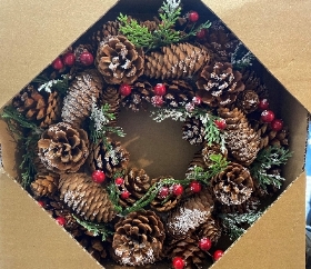 Pine cone wreath with snow and red berries